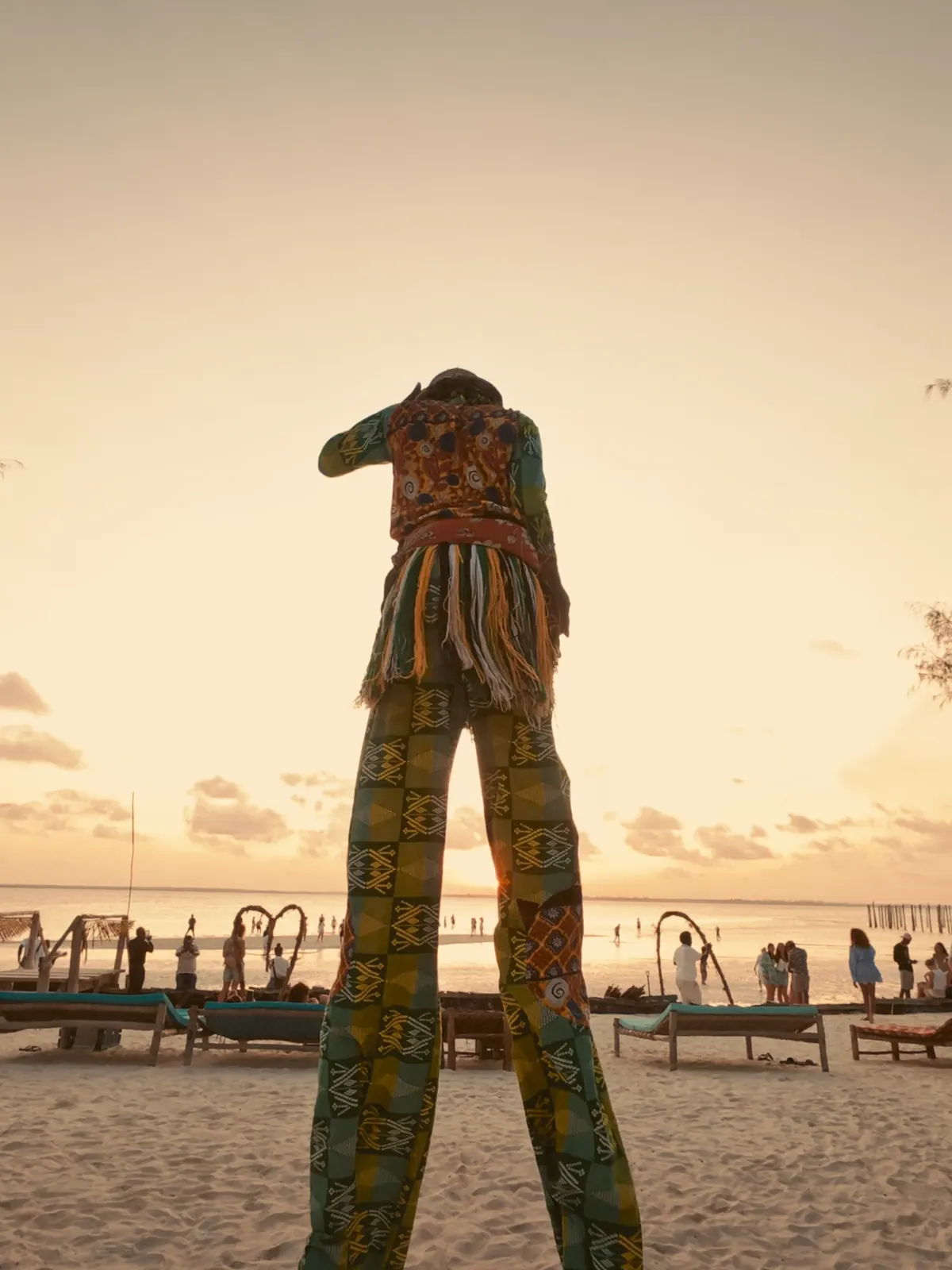 Stilt walker on the beach at sunset, Kae Funk