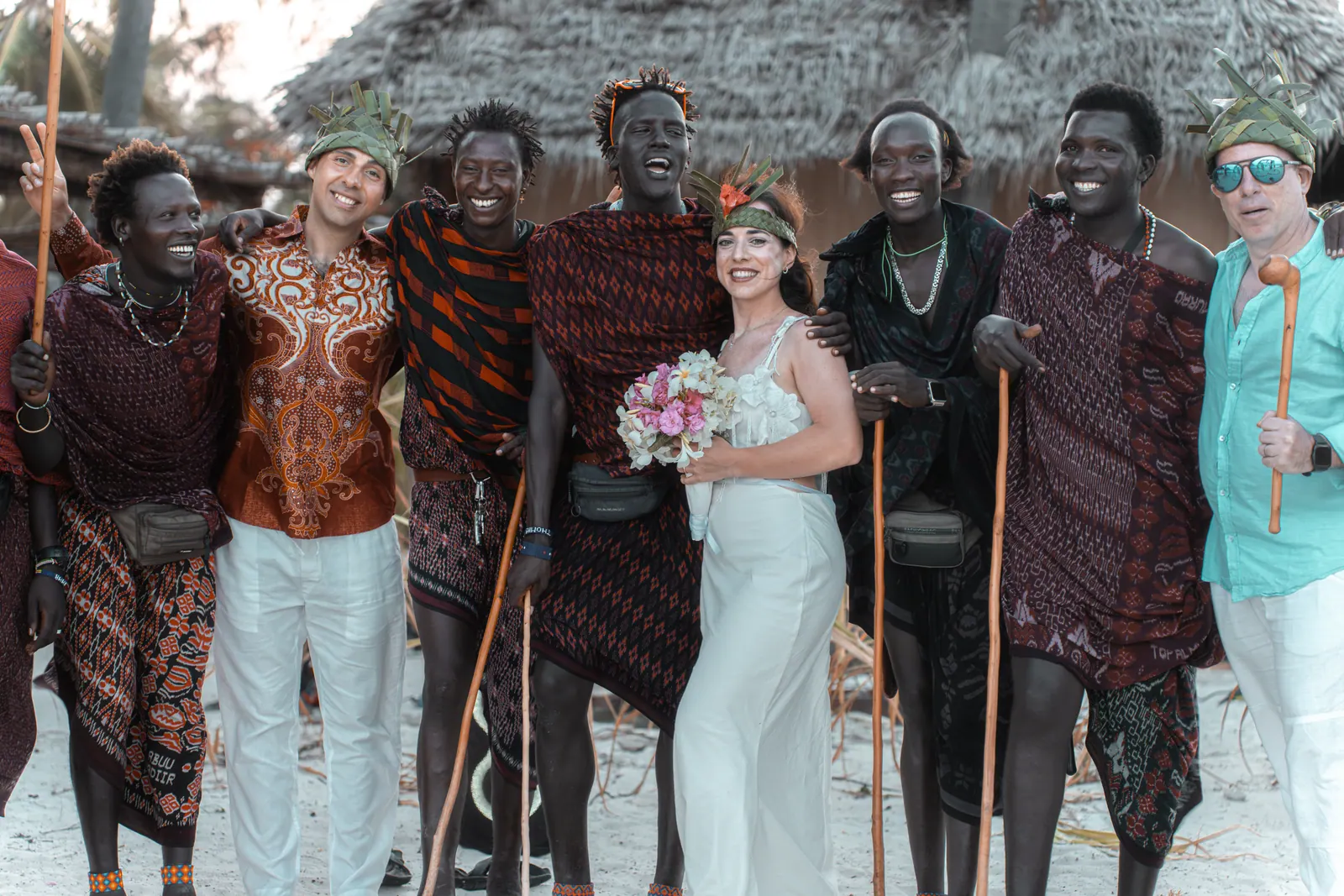 The couple with Maasai dancers and guests in front of the bungalows