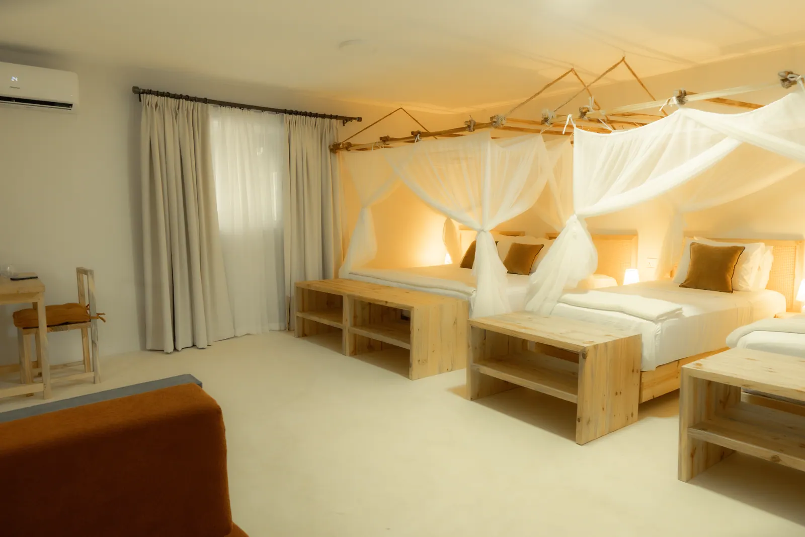 Canopy bed with mosquito net and bedside lamps in warm evening light